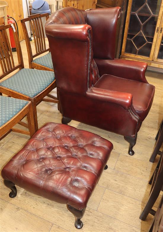 A button back leather wing armchair with footstool